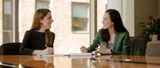 Two women having a conversation at a conference table